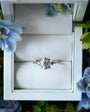 Diamond ring in a white box with floral decorations