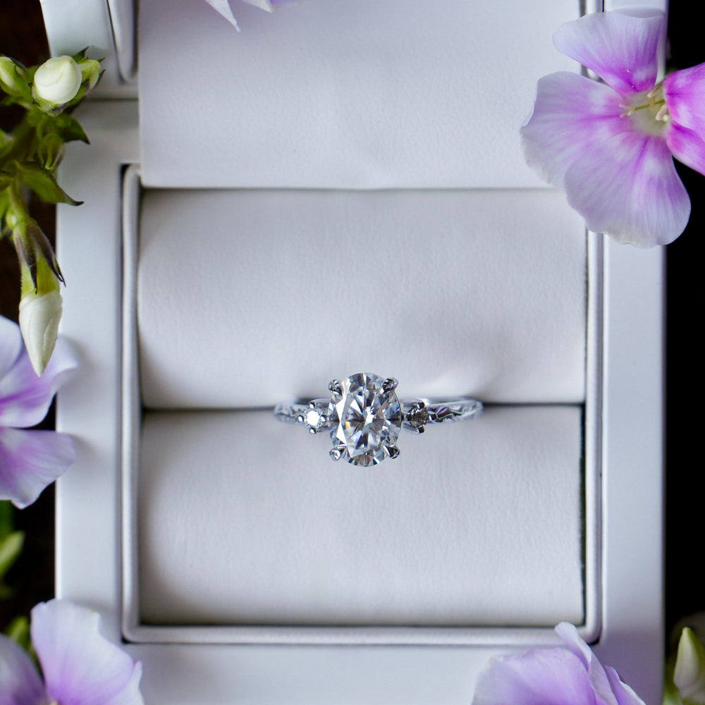 Diamond ring in a box with purple flowers around