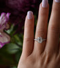 Diamond ring on a hand with a blurred floral background