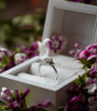 Diamond ring in a white box with flowers around